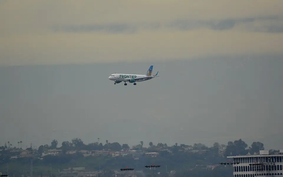 Frontier Airlines Airbus A320 descending on approach through a hazy sky
