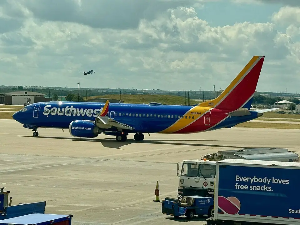 Southwest Airlines Boeing 737 MAX 8 taxiing on the ramp with ground vehicles nearby