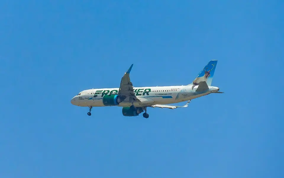Frontier Airlines Airbus A320 in flight against a clear blue sky