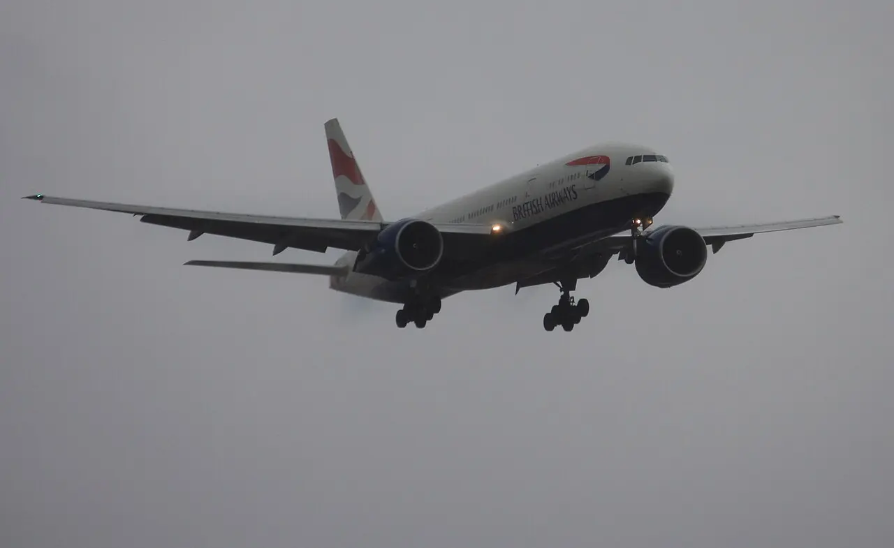 British Airways Boeing 777 descending on approach through overcast skies