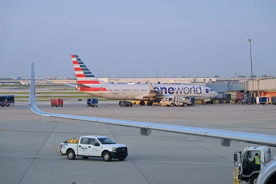 American Airlines Boeing 737 parked at the gate with ground service vehicles nearby