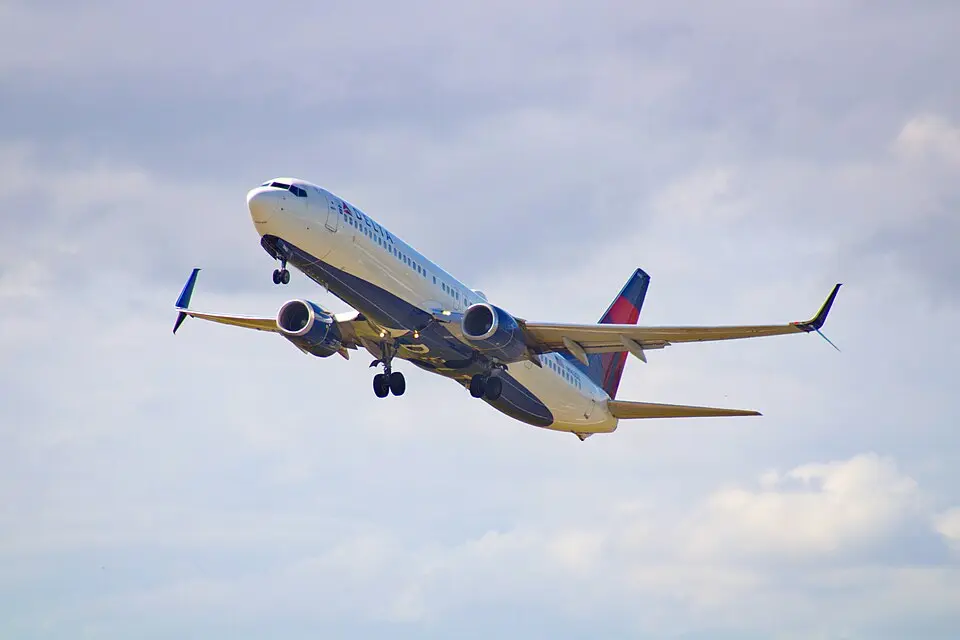 Delta Air Lines Boeing 737 climbing out after takeoff against a partly cloudy sky