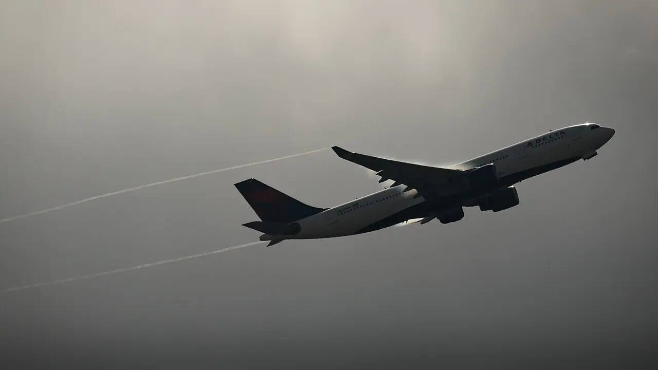 Delta Air Lines Airbus A330 climbing into a hazy sky with contrails trailing behind