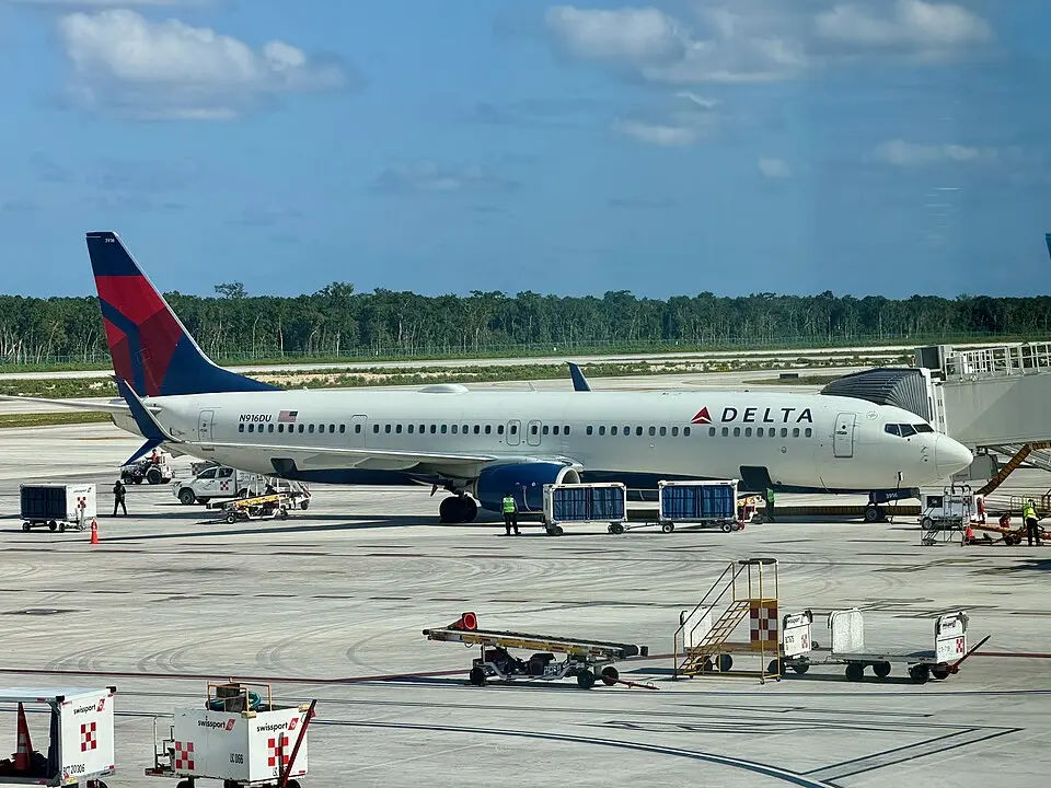 Delta Air Lines Boeing 737 parked at the gate with ground crew working nearby