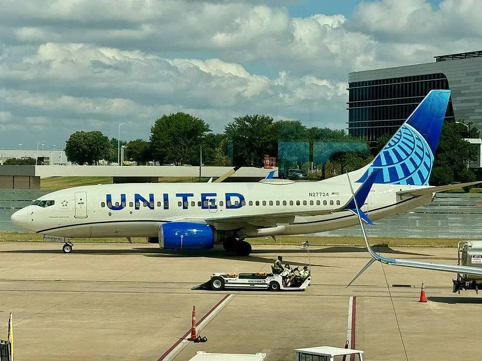United Airlines Boeing 737 taxiing on the ramp near an office building